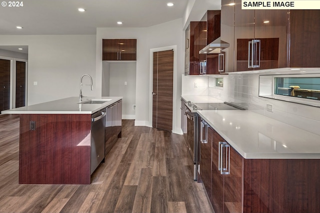 kitchen with tasteful backsplash, sink, stainless steel appliances, dark wood-type flooring, and a kitchen island with sink