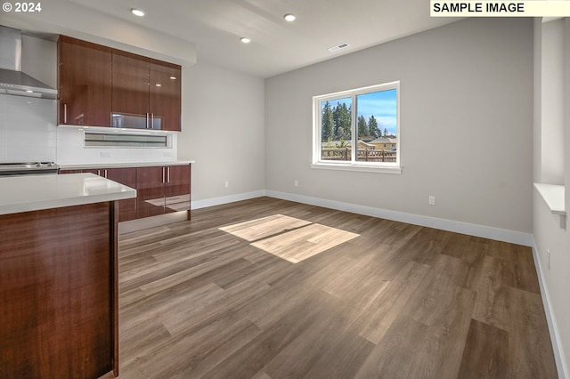 kitchen with wall chimney range hood, stainless steel range oven, tasteful backsplash, and dark hardwood / wood-style flooring