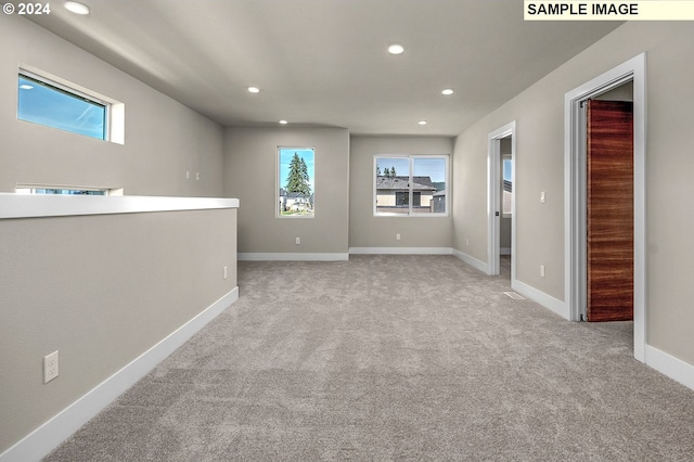 empty room featuring plenty of natural light and light colored carpet