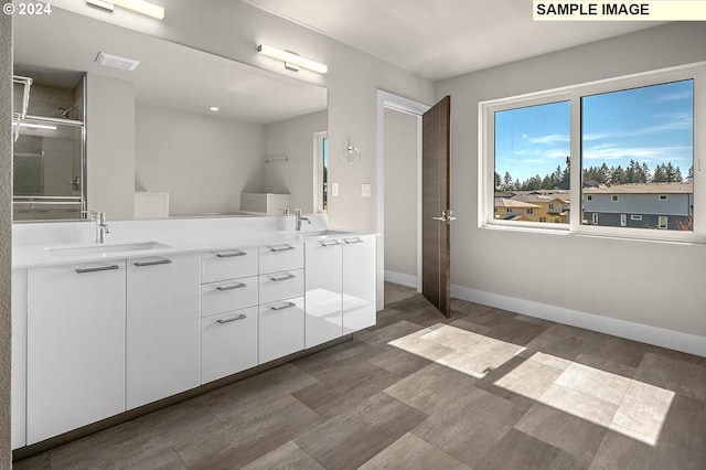 bathroom with vanity and a shower with door