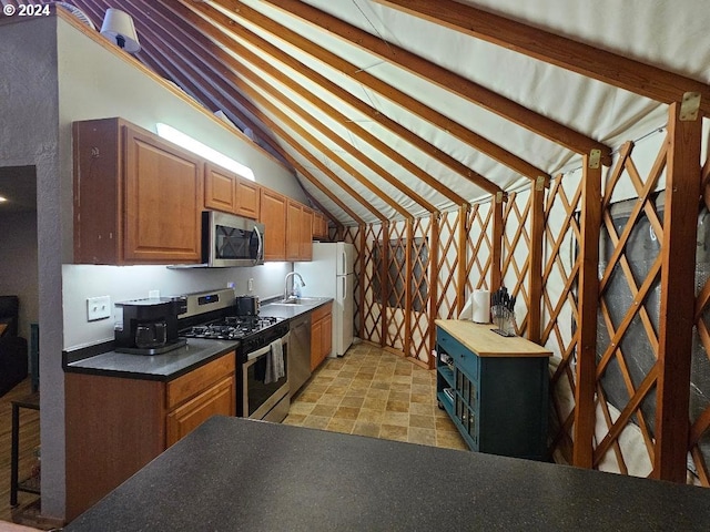 kitchen featuring lofted ceiling with beams, sink, and appliances with stainless steel finishes