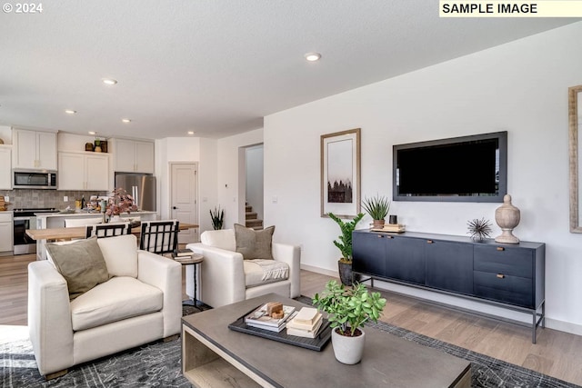 living room with stairway, baseboards, wood finished floors, and recessed lighting