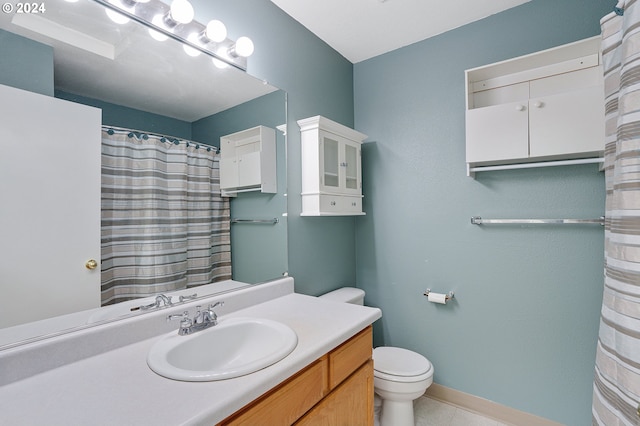 bathroom featuring tile patterned flooring, vanity, and toilet