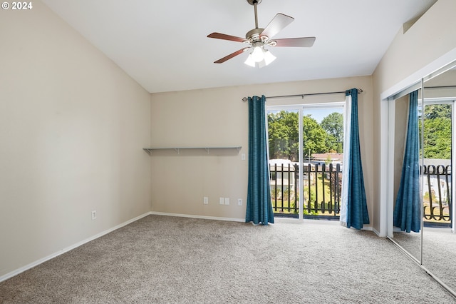 carpeted spare room featuring a wealth of natural light, lofted ceiling, and ceiling fan