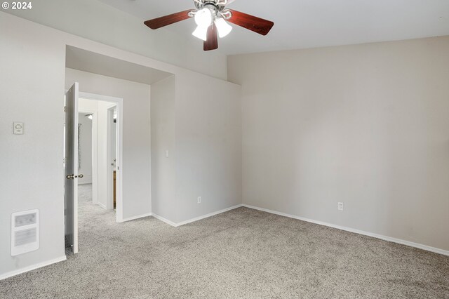 unfurnished room with heating unit, light carpet, and ceiling fan