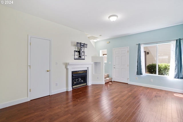 unfurnished living room with dark wood-type flooring