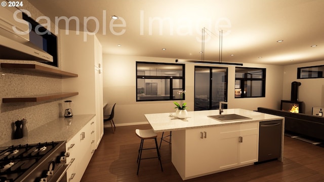 kitchen with light stone counters, sink, a center island with sink, white cabinetry, and hanging light fixtures