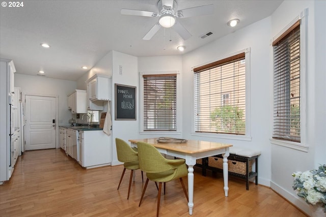 dining space featuring light hardwood / wood-style floors, ceiling fan, and sink