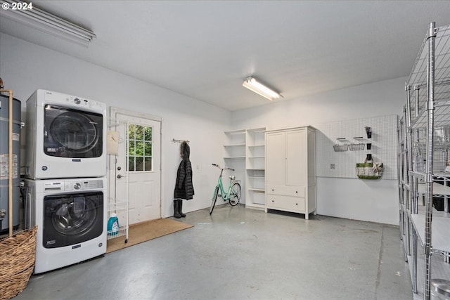 clothes washing area with stacked washer and dryer and water heater