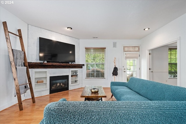 living room with hardwood / wood-style flooring and a tiled fireplace