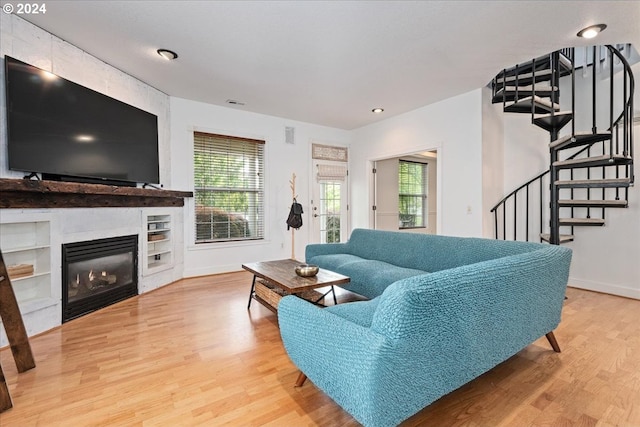 living room with a tile fireplace and wood-type flooring