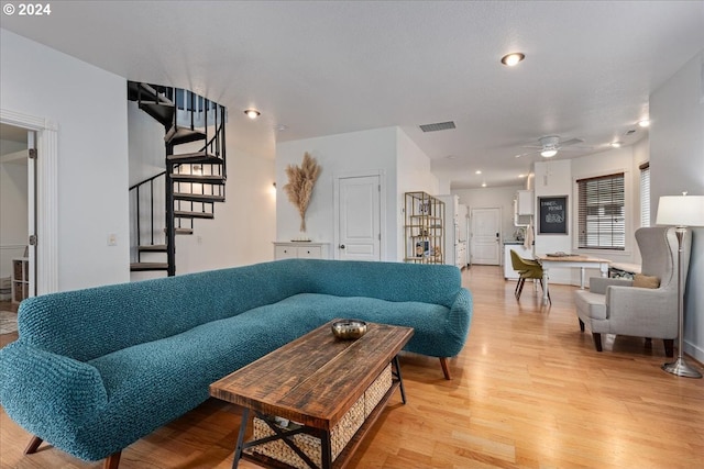 living room with ceiling fan and light hardwood / wood-style floors