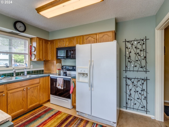 kitchen with a textured ceiling, white appliances, light colored carpet, and sink