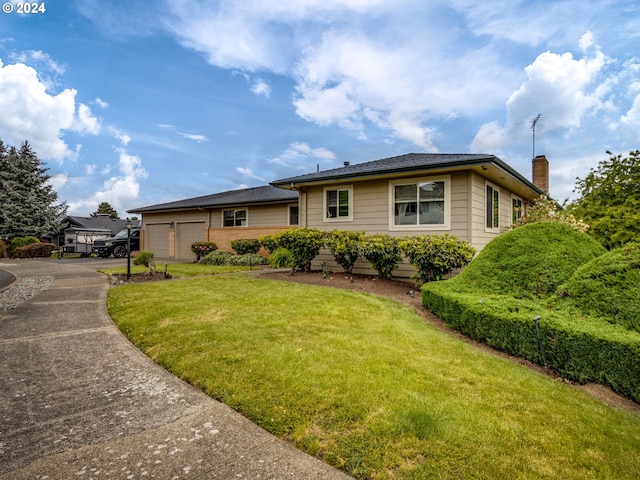 view of front of property with a front yard and a garage