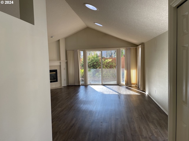 unfurnished living room with a textured ceiling, dark hardwood / wood-style flooring, a fireplace, and vaulted ceiling