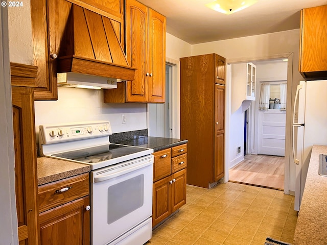 kitchen featuring light hardwood / wood-style floors, white appliances, and premium range hood