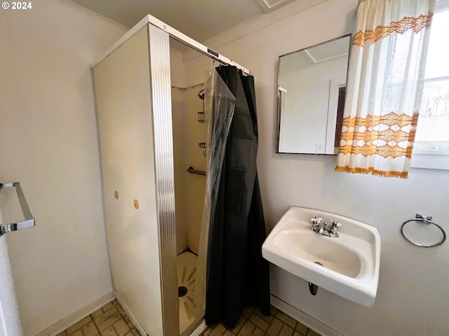 bathroom with crown molding, sink, and walk in shower