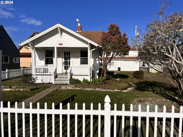 bungalow-style home with covered porch and a front lawn