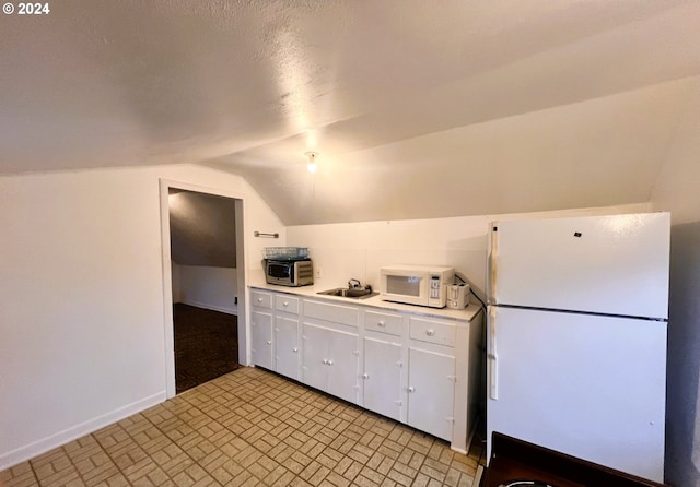 kitchen with white cabinetry, sink, vaulted ceiling, a textured ceiling, and white appliances