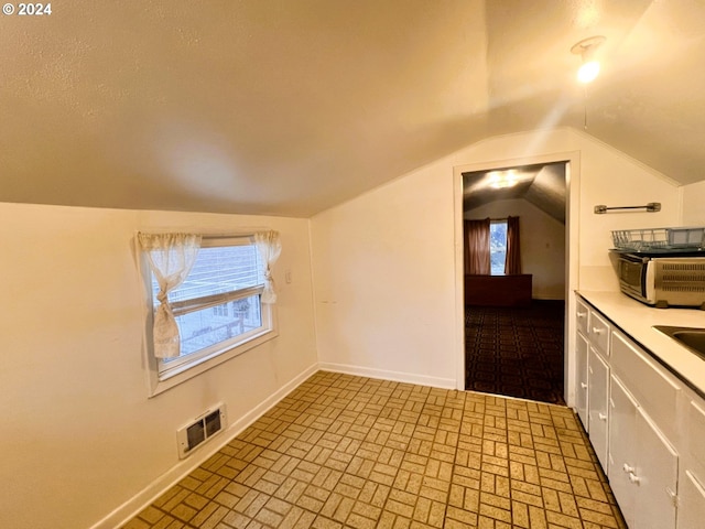 interior space featuring sink and lofted ceiling