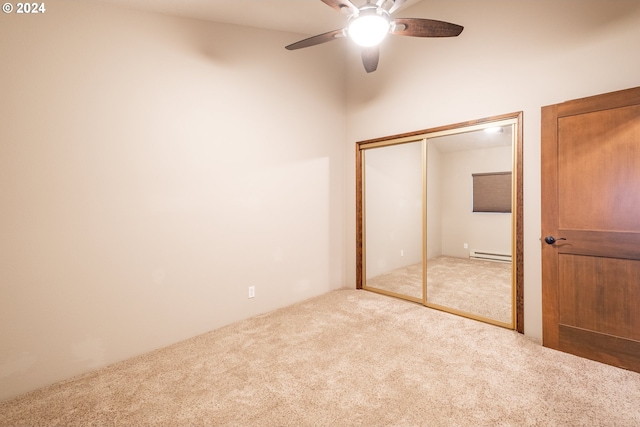 unfurnished bedroom with a closet, carpet floors, baseboard heating, and ceiling fan