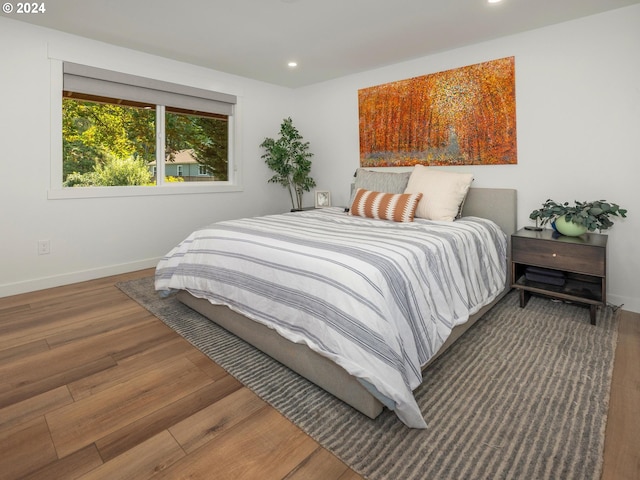 bedroom with dark hardwood / wood-style flooring