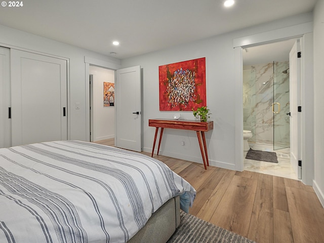 bedroom featuring ensuite bathroom, a closet, and light hardwood / wood-style floors