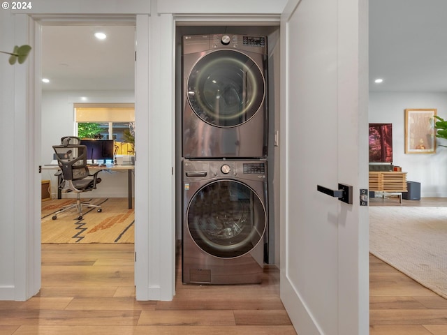 laundry area featuring stacked washer and dryer and hardwood / wood-style floors