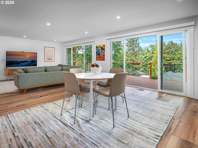 dining area with light hardwood / wood-style floors and a wealth of natural light