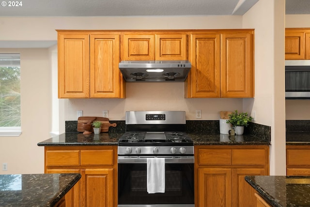 kitchen with gas stove and dark stone counters