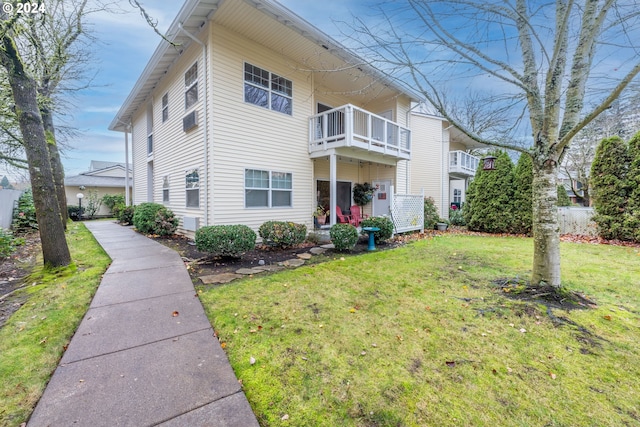 exterior space featuring a balcony and a front lawn