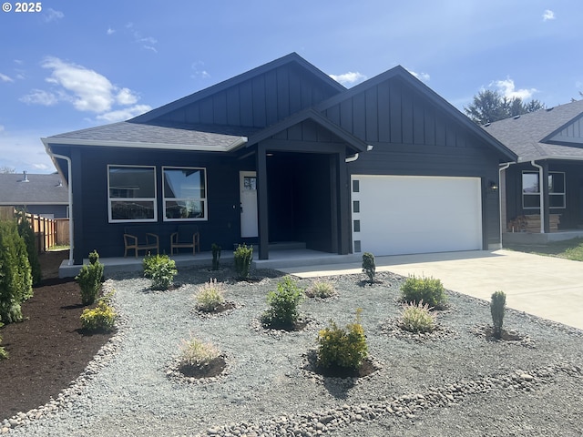 view of front of home with board and batten siding, concrete driveway, a garage, covered porch, and fence