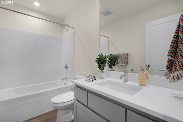 bathroom featuring toilet, vanity, wood finished floors, shower / tub combination, and recessed lighting