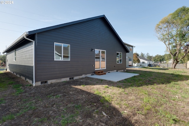 back of property with a patio, entry steps, and a lawn
