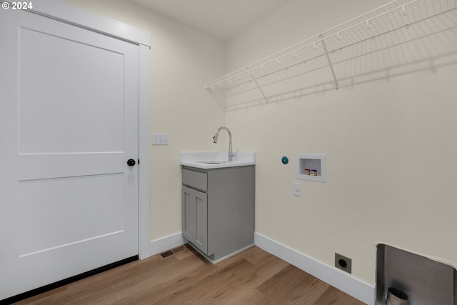 clothes washing area featuring hookup for an electric dryer, sink, light hardwood / wood-style flooring, and washer hookup