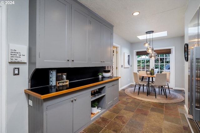 kitchen with stainless steel fridge with ice dispenser, decorative light fixtures, and gray cabinets