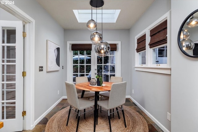 dining area with french doors and a skylight