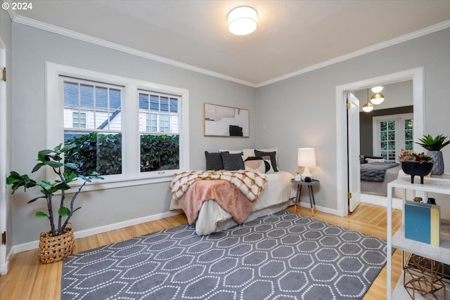 bedroom with wood-type flooring, crown molding, and multiple windows