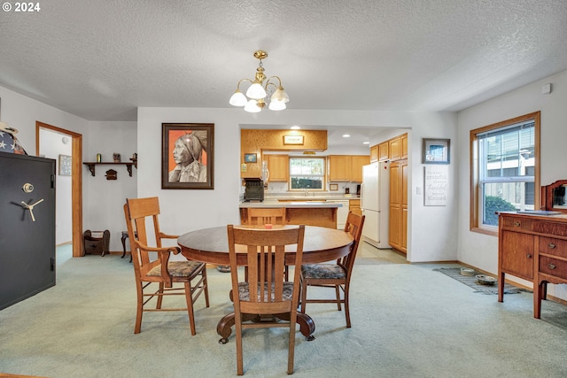 dining area with a textured ceiling, light carpet, and a notable chandelier