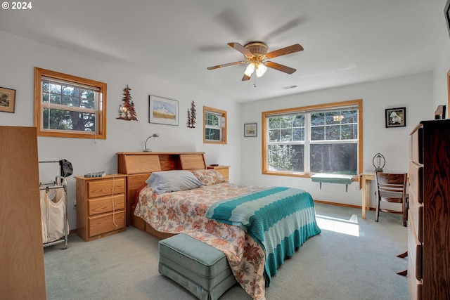 carpeted bedroom featuring multiple windows and ceiling fan