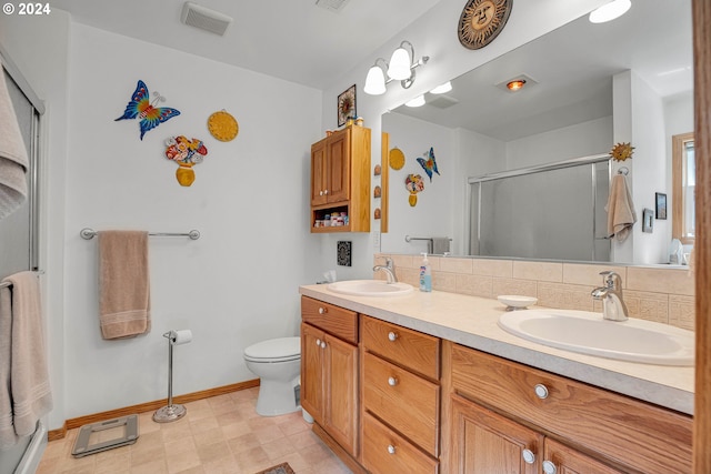 bathroom featuring tasteful backsplash, vanity, toilet, and an enclosed shower