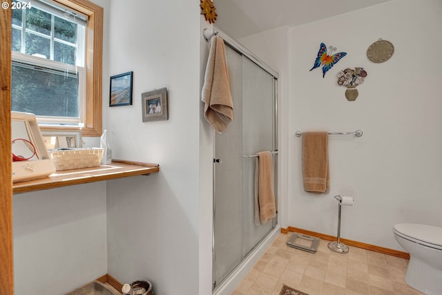 bathroom with toilet and an enclosed shower