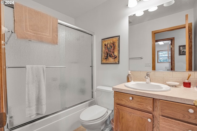 full bathroom with enclosed tub / shower combo, backsplash, vanity, and toilet