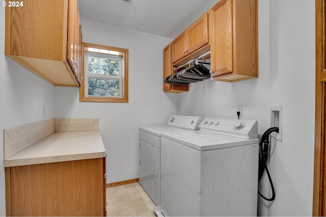 washroom featuring cabinets and washing machine and clothes dryer