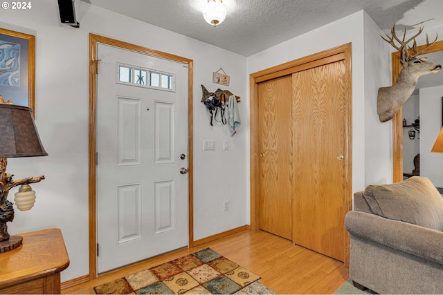 foyer featuring light wood-type flooring and a textured ceiling