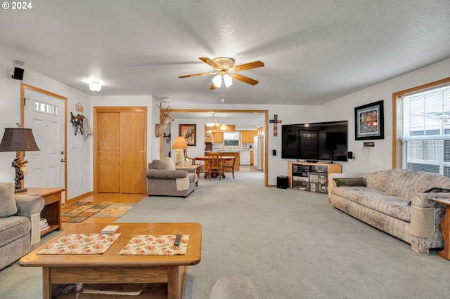 carpeted living room with ceiling fan with notable chandelier and a textured ceiling