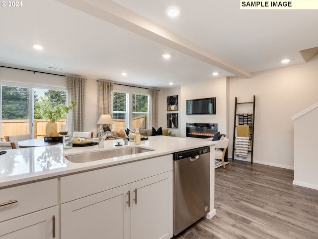 kitchen with stainless steel dishwasher, white cabinets, sink, and light hardwood / wood-style flooring