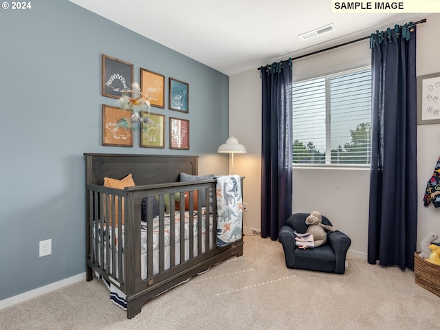 bedroom featuring carpet and a nursery area