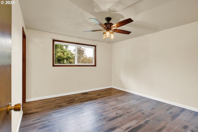 spare room featuring ceiling fan, dark hardwood / wood-style floors, and a textured ceiling