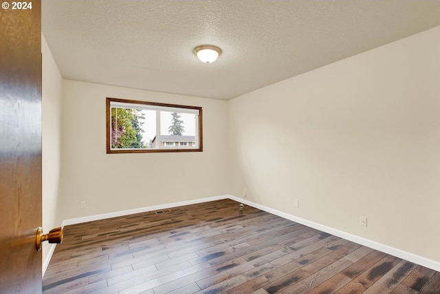 spare room with hardwood / wood-style floors and a textured ceiling